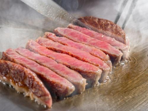 a bunch of bacon being cooked on a grill at Art Hotel Hirosaki City in Hirosaki