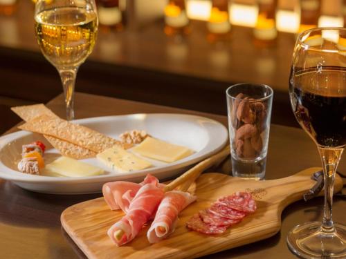 a table with a plate of food and a glass of wine at Art Hotel Hirosaki City in Hirosaki