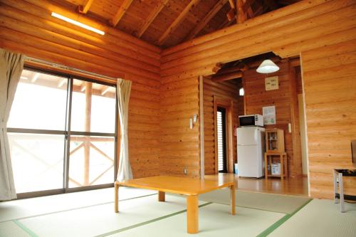 a room with a wooden wall with a table and a refrigerator at 美濃田の淵キャンプ村 in Higashimiyoshi