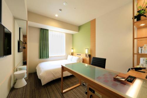 a hotel room with a bed and a desk at Candeo Hotels Hiroshima Hatchobori in Hiroshima