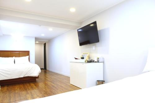Habitación de hotel con cama y TV de pantalla plana. en Charm Hotel en Seúl