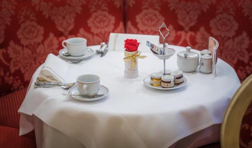 a white table with cups and saucers on it at Schlosshotel Römischer Kaiser in Vienna