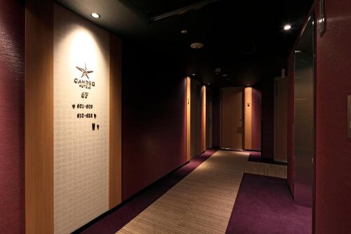 a hallway with a wall with a sign on it at Candeo Hotels Hiroshima Hatchobori in Hiroshima