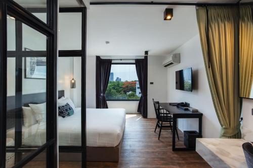 a hotel room with a bed and a desk at Oriental Heritage Residence in Bangkok