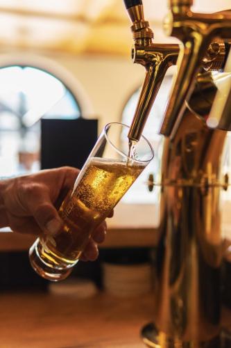 a person is holding a glass of beer at Roggenstock Lodge in Oberiberg