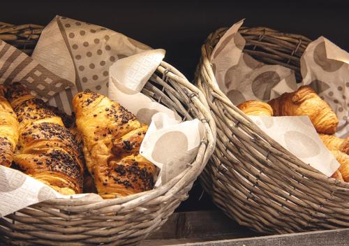 two baskets filled with bread and pastries on a table at Atelier Hotel in Ljubljana