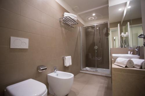 a bathroom with a toilet, sink and shower at Airone City Hotel in Catania