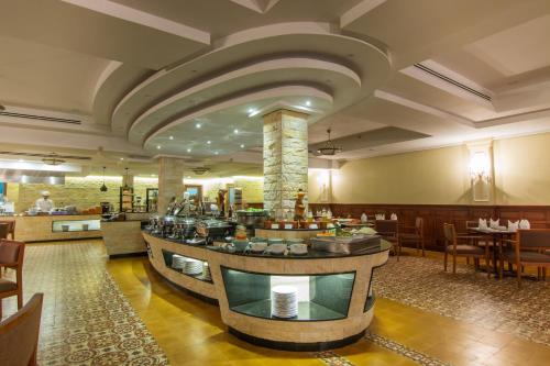 a restaurant with a bar in the middle of a room at Angkor Palace Suite & Villa in Siem Reap