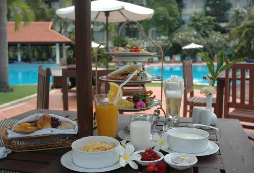 a table with breakfast foods and drinks on it at Angkor Palace Suite & Villa in Siem Reap