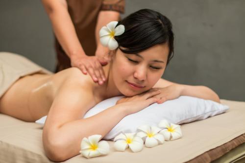 a woman getting a massage in a bed at Angkor Palace Suite & Villa in Siem Reap