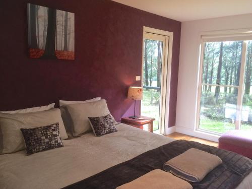 ein Schlafzimmer mit einem großen Bett und einem Fenster in der Unterkunft Haven Hideaway in Berry