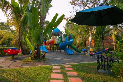 a playground with a slide and an umbrella at Angkor Palace Suite & Villa in Siem Reap