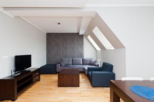 a living room with a couch and a tv at Apartamenty Sun & Snow Centrum in Zakopane