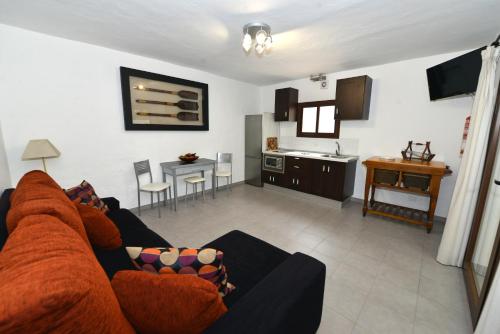 a living room with a couch and a kitchen at Apartamentos Finca Wapa in Frontera