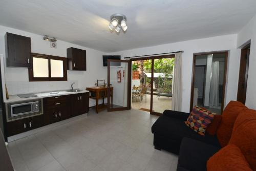 a living room with a couch and a kitchen at Apartamentos Finca Wapa in Frontera