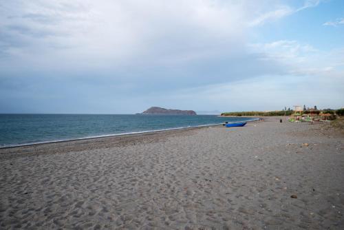 a beach with a blue boat in the water at Electra Studios in Gerani Chanion