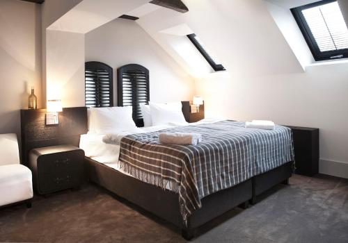 a bedroom with a large bed in a room with windows at Hotel Pałac Jugowice in Wałbrzych