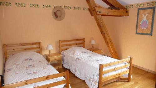 deux lits jumeaux dans une chambre avec poutres en bois dans l'établissement Gîte du Pilan, à Portieux