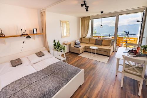 1 dormitorio con 1 cama y sala de estar en MOOKI Mountain & Pool Gerlitzen Apartment, en Kanzelhöhe