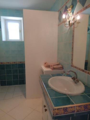 a bathroom with a sink and a toilet and a mirror at Chateau Rousselle in Saint-Ciers-de-Canesse