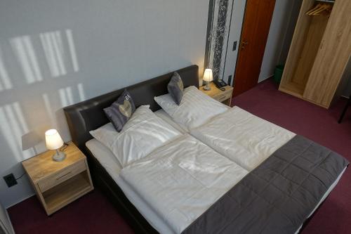 un letto con lenzuola e cuscini bianchi in una camera da letto di Goldener Löwe Triebes a Triebes
