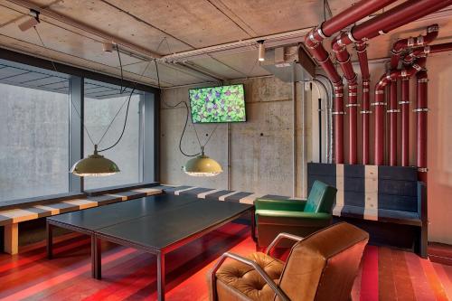 a room with a table and chairs and a tv at Anda Venice Hostel in Mestre