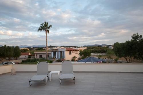 two white chairs sitting on top of a patio at Electra Studios in Gerani Chanion