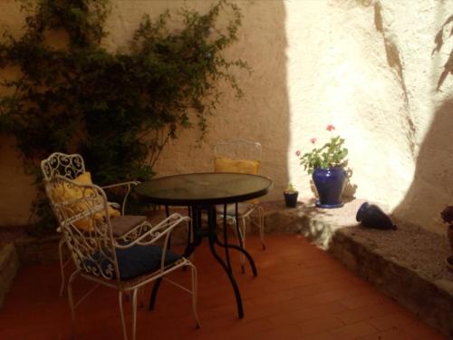 een tafel en stoelen in een patio met een tafel en stoelen bij Tranquil Spanish Mountain Retreat in Benirrama