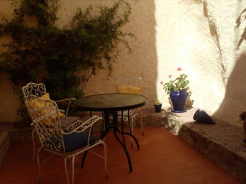 a table and chairs in a patio with a table and chairs at Tranquil Spanish Mountain Retreat in Benirrama