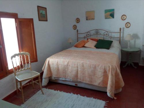 - une chambre avec un lit, une chaise et une fenêtre dans l'établissement Tranquil Spanish Mountain Retreat, à Benirrama