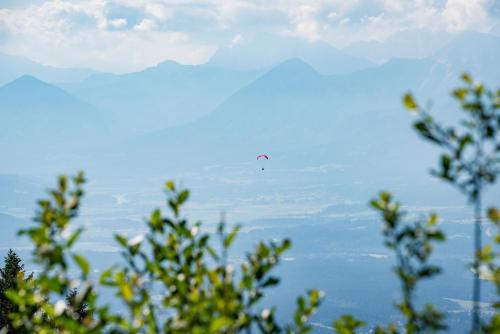 a kite flying in the sky over the mountains at MOOKI Mountain & Pool Gerlitzen Apartment in Kanzelhöhe
