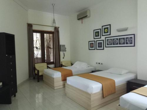 a hotel room with two beds and a television at GK Gallery Rumah Sewa in Purwokerto
