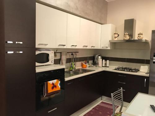 a kitchen with white cabinets and a stove top oven at Casa Angela in Avola