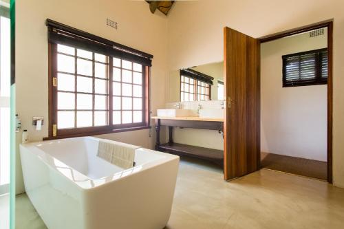a large bathroom with a tub and a sink at iNsingizi Lodge in Mid Illovo