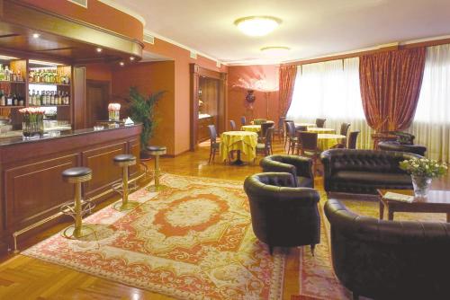 a restaurant with a bar with chairs and tables at Hotel Maxim in Peschiera Borromeo