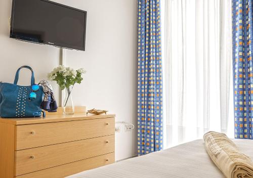 a bedroom with a dresser with a television on top of it at Casa Lucia Centro Apartment Deluxe in Sottomarina