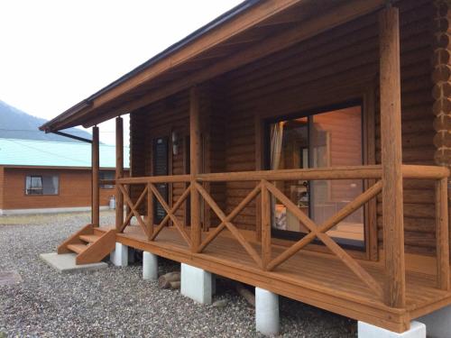 a log cabin with a large window on the porch at 美濃田の淵キャンプ村 in Higashimiyoshi