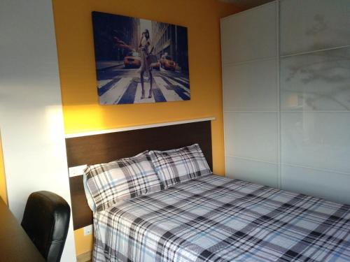 ビトリア・ガステイスにあるApartamento céntricoのベッドルーム1室(ベッド1台付)が備わります。壁に絵が飾られています。