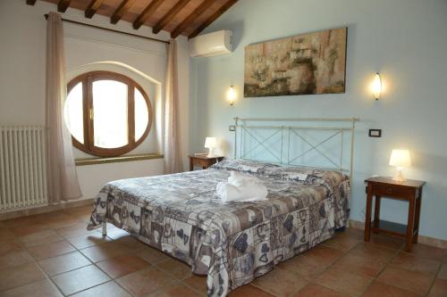 1 dormitorio con cama y ventana grande en Residence Il Granaio, en Riparbella