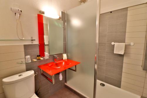 a bathroom with a red sink and a shower at Hôtel le Chardon Bleu in Sainte-Maxime