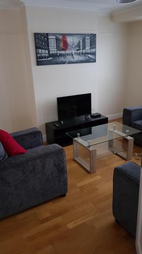 a living room with two couches and a flat screen tv at Elegant and spacious 2 bedroom in Barnet