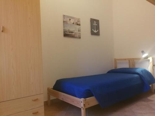 um quarto com uma cama com um cobertor azul em Mandriola Putzuidu Capo Mannu em Putzu Idu