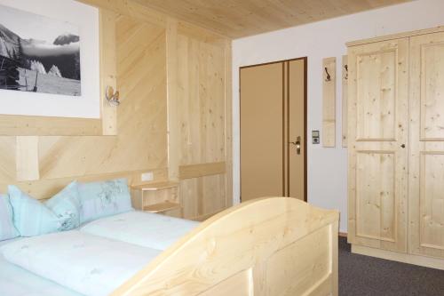 a bedroom with a wooden bed and a door at Ferienhaus Tirolerhof in Kals am Großglockner