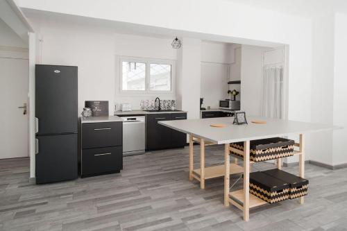 una cucina con tavolo e armadietti neri di Grand appartement lumineux Toulon Centre Ville a Tolone