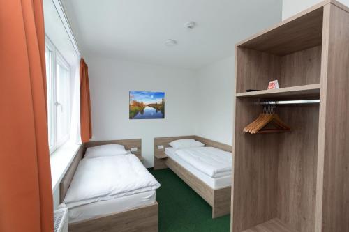 a small room with two beds and a window at WinBudget Guntramsdorf in Guntramsdorf