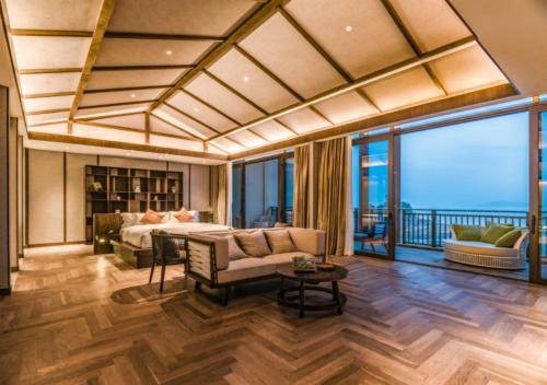 a bedroom with a bed and a living room at Angsana Zhuhai Phoenix Bay in Zhuhai