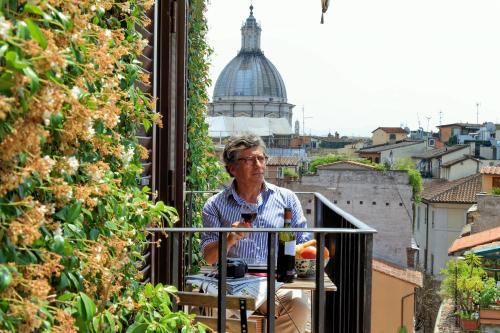 a man sitting on a balcony looking out of a window at Terrazze Navona in Rome