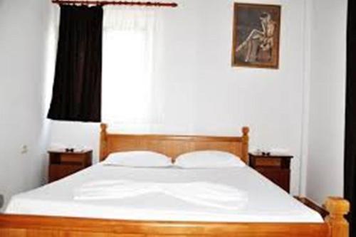 a bedroom with a bed with white sheets and a window at Apartments Beti in Ulcinj
