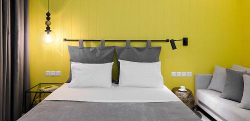 a bed with white pillows and a couch in a room at Castristudios in Nikiti