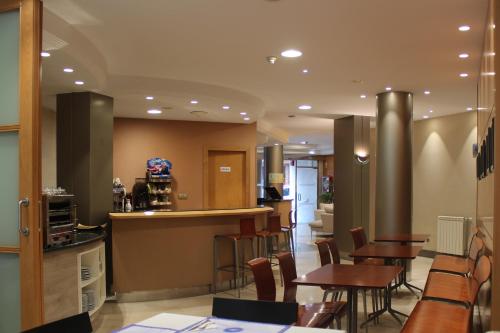 a restaurant with tables and chairs and a counter at Hotel Carreño in Oviedo